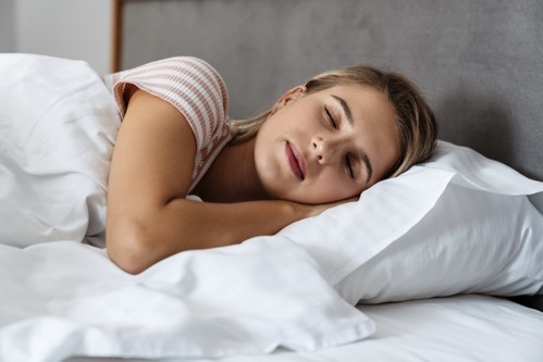 beautiful young woman sleeping in bed EYQGCSQ 1